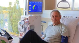 Dialysepatiënt Simon, die tijdens zijn behandeling uitkijkt op de groene omgeving